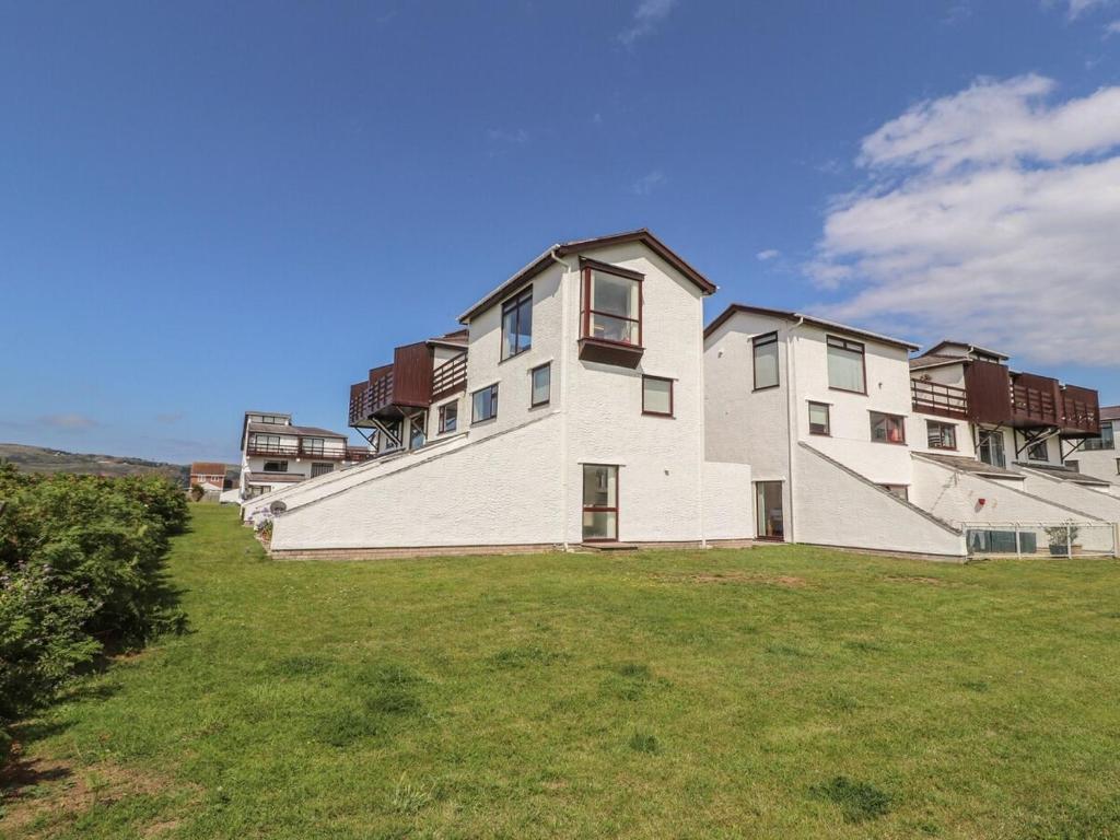 a large white building on top of a grass field at Sunset Sands in Deganwy