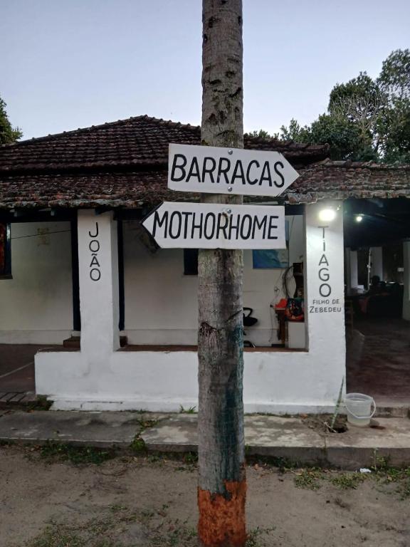 a street sign on a pole in front of a store at Itaúna Surf Camping in Saquarema