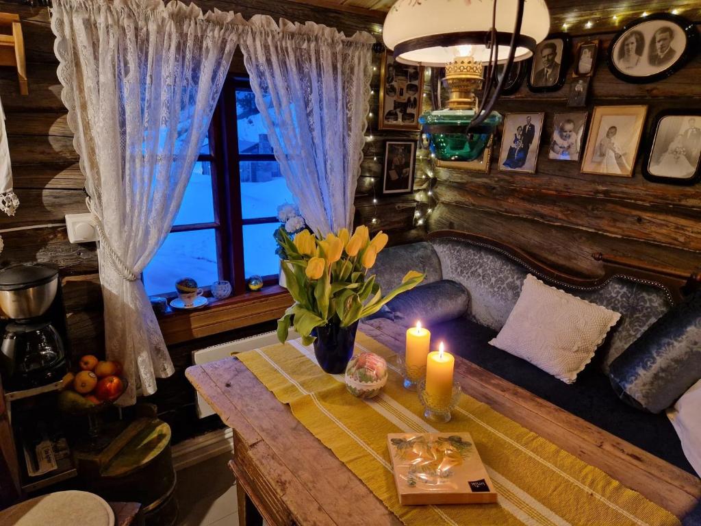 a living room with a table with candles and a couch at Smia cabin , A Unique Rustic Hideaway in Lii