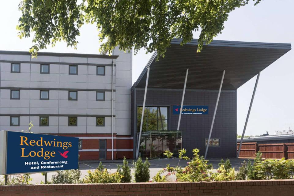 a building with a sign in front of it at Redwings Lodge Birmingham in Oldbury