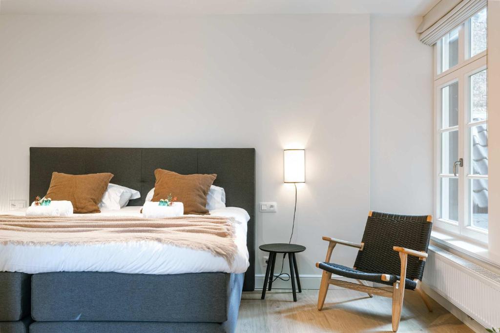 a bedroom with a large bed and a chair at Apartment near Antwerp Cathedral in Antwerp