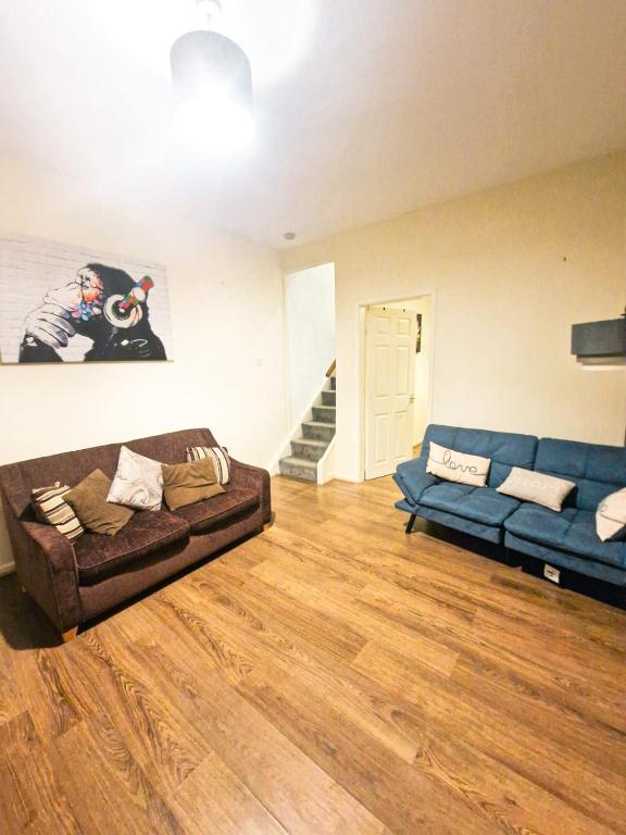 a living room with a brown couch and blue couches at Leyland Town Centre Quiet Hub 2 bedroom 4 beds superfast WIFI free parking close to station and High Street in Leyland
