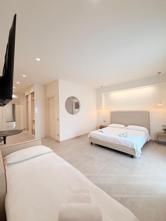 a bedroom with two beds and a flat screen tv at Ab aparthotel in Gizzeria