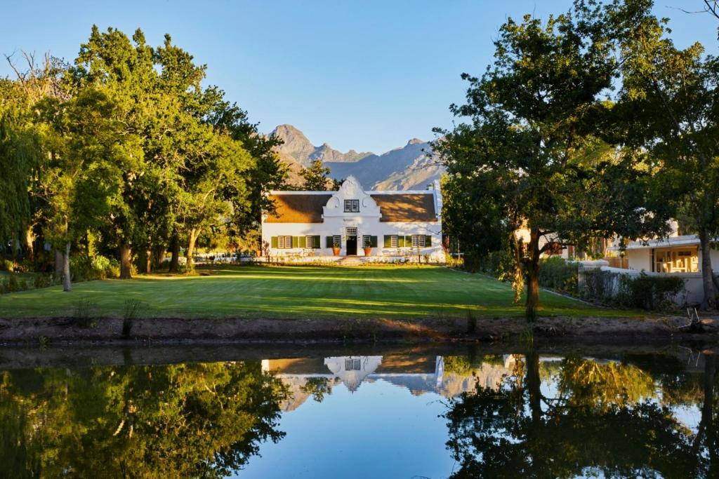 a house with a pond in front of it at Blaauwklippen Manor by NEWMARK in Stellenbosch