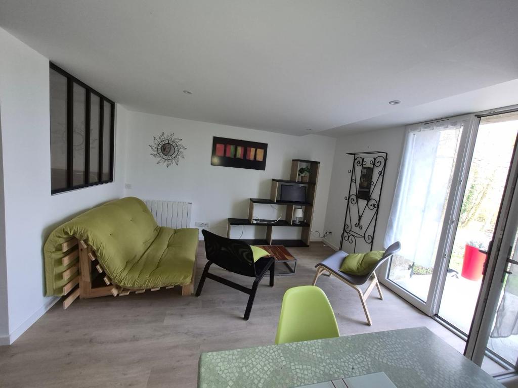 a living room with a green couch and chairs at Chez Helje in Les Essards-Taignevaux