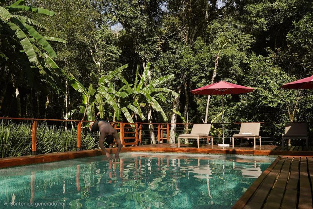 a person standing in the water in a swimming pool at ANAVÁ Lodge de Selva y Piscina privada in El Soberbio