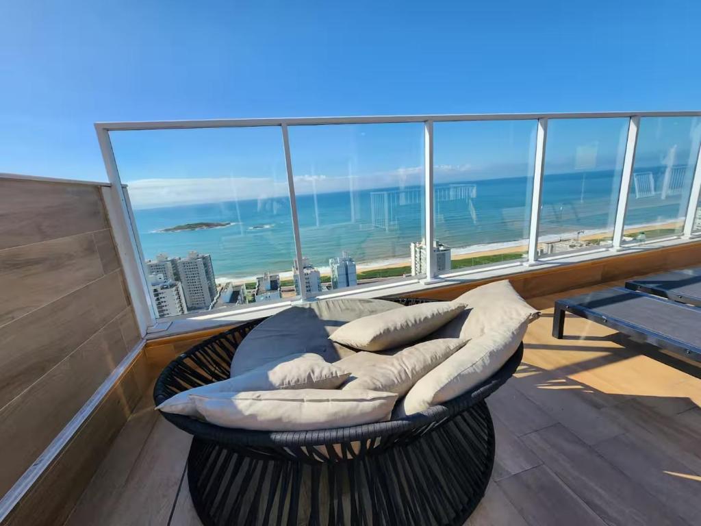 a balcony with a bed and a view of the ocean at Nas Nuvens em Itaparica in Vila Velha