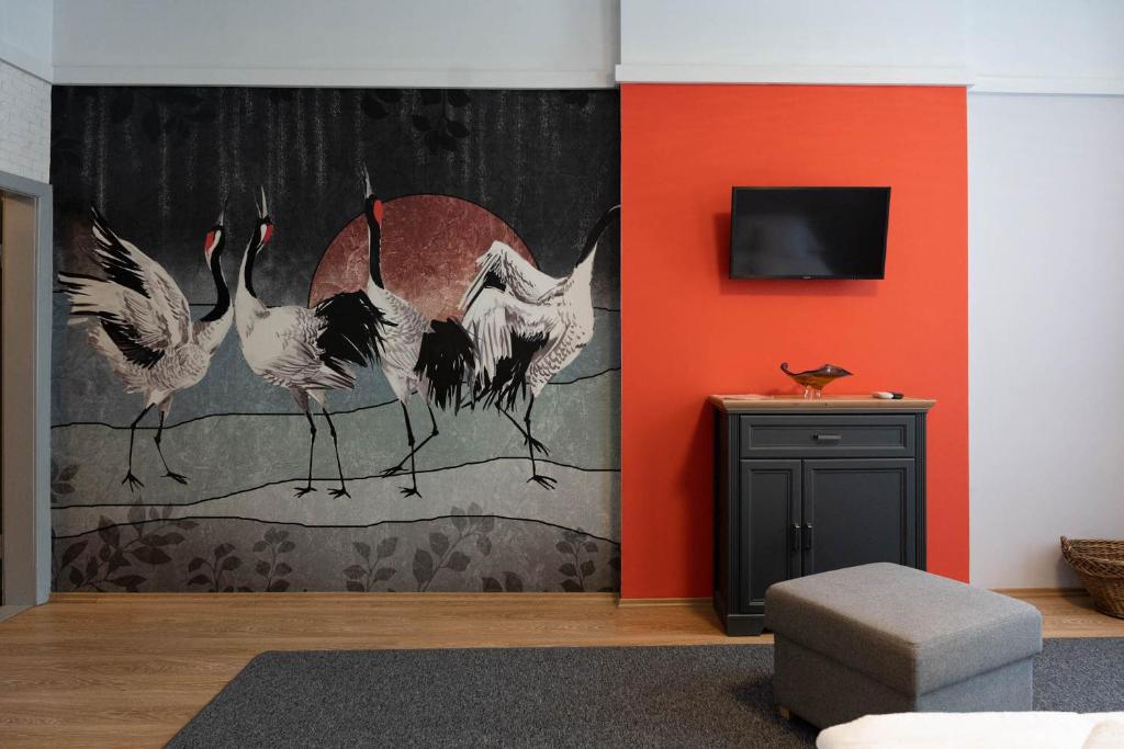 a room with a wall with a painting of flamingos at Csaba Vendégház in Izsák