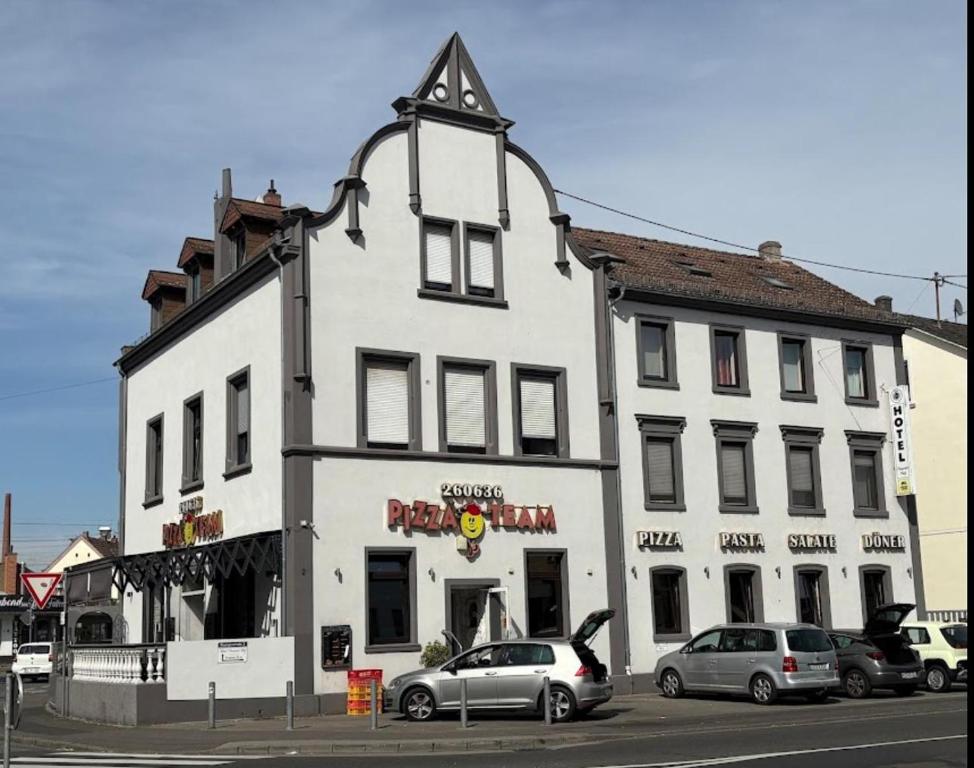 a white building with cars parked in front of it at Nassauer Hof Wiesbaden-Schierstein in Wiesbaden