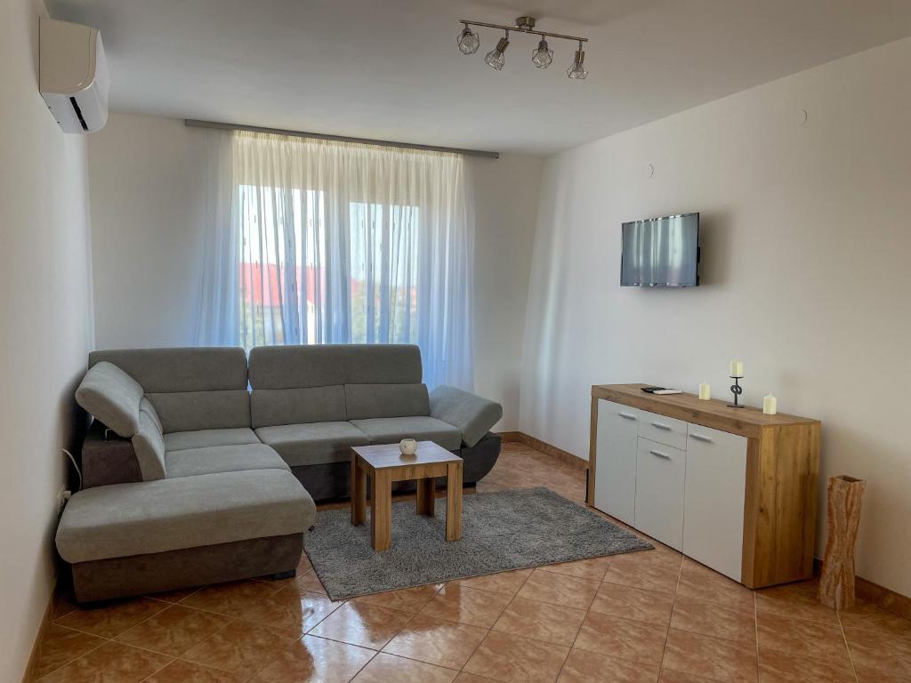 a living room with a couch and a table at Hársfa Central Apartment in Mórahalom