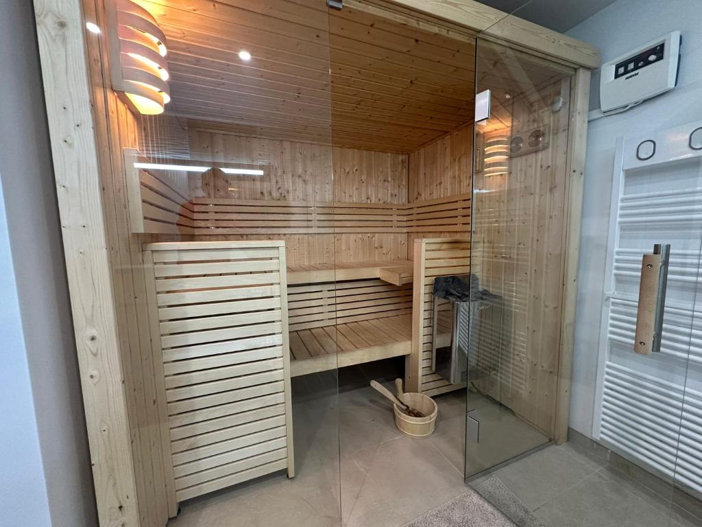 a sauna with wooden walls and a glass door at Chambre-Studio et SAUNA indépendants in Annecy