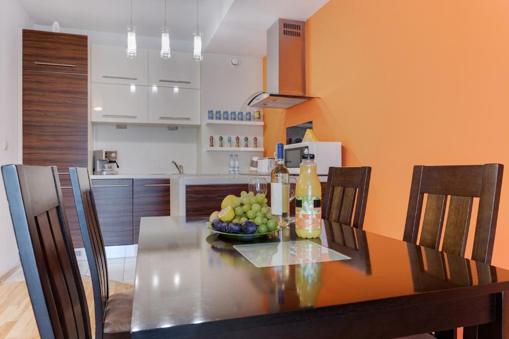 a dining room table with a bowl of fruit on it at Apartments of Pawia in Krakow