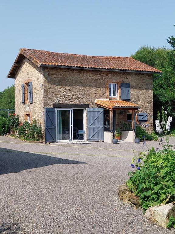 a stone house with its doors open on a driveway at Beautiful 2 bed cottage with swimming pool in Pagéas