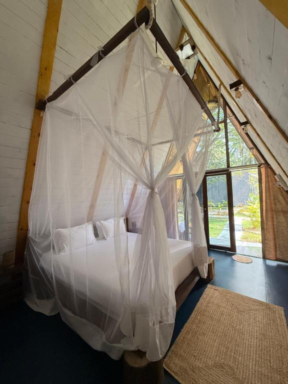 a bedroom with a bed covered in mosquito nets at Luma in Palolem