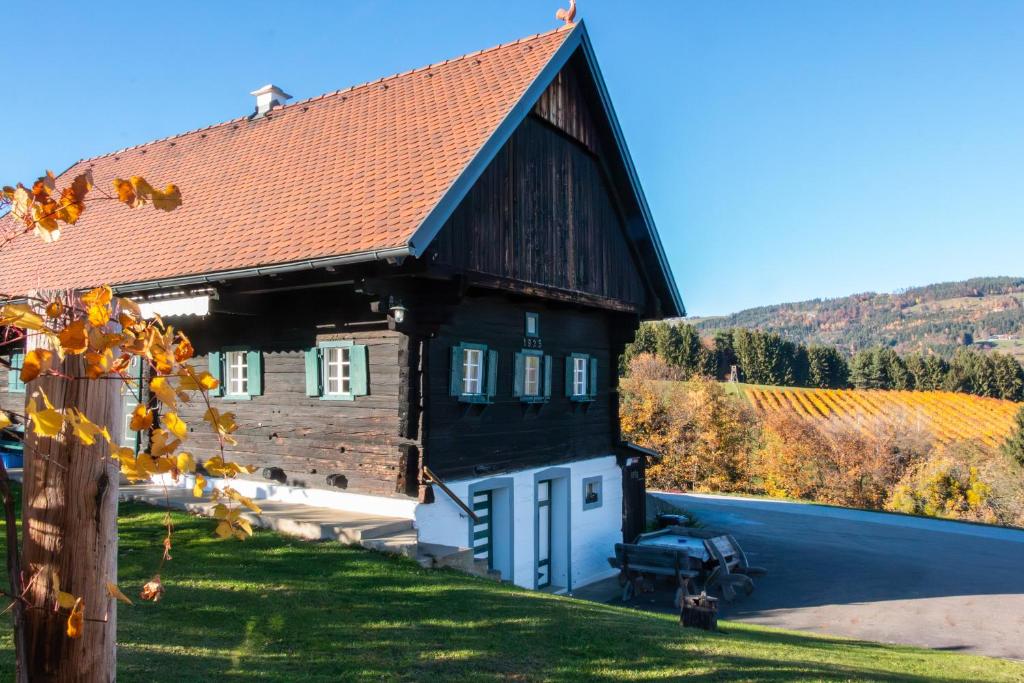 a large black house with a red roof at Winzerhaus Löscherannerl in Kogl