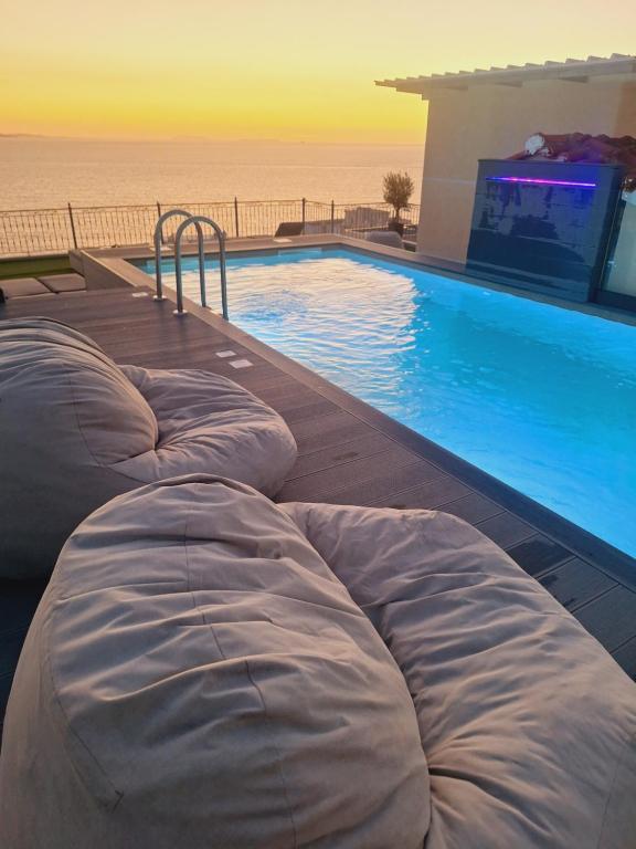 a swimming pool with two bean bags next to the ocean at PARADISE APARTMENT in Sarandë