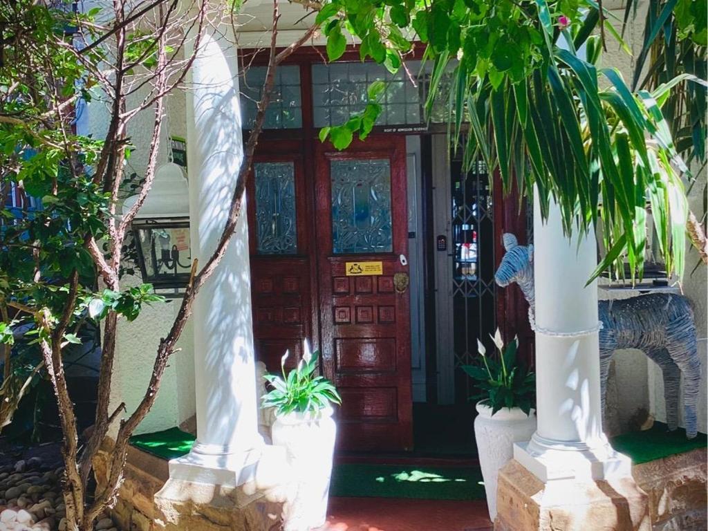 a front door of a house with potted plants at Ashby Manor Guest House in Cape Town