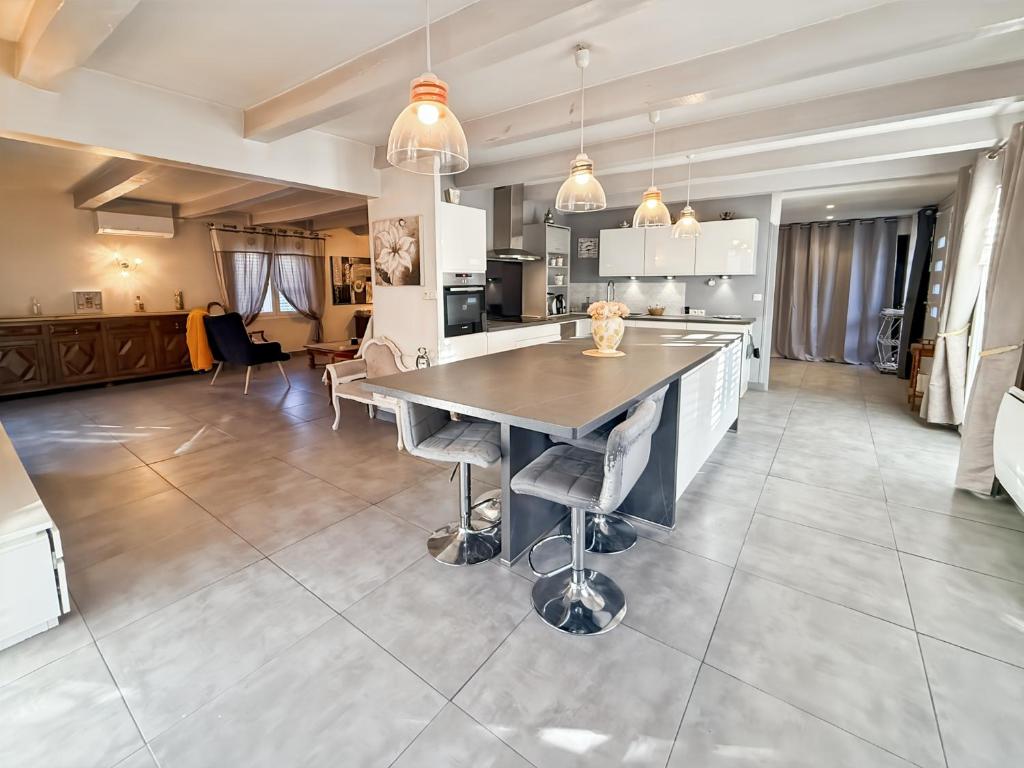 a large kitchen with a table and some chairs at Maison 4 ch, véranda, proche commodités, Aurillac in Aurillac
