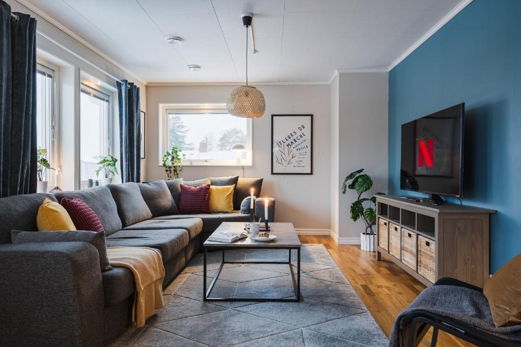 a living room with a couch and a tv at Guestly Homes - Spacious Top Floor 2BR Residence in Luleå
