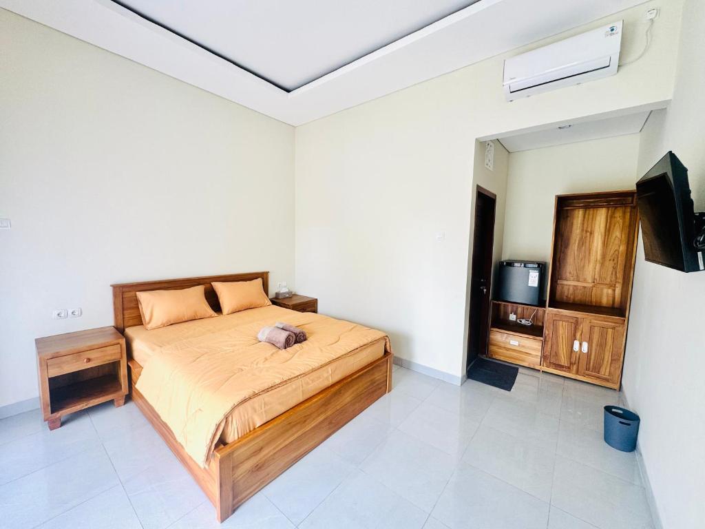 a bedroom with a bed and a tv in it at Umah Anami in Jimbaran