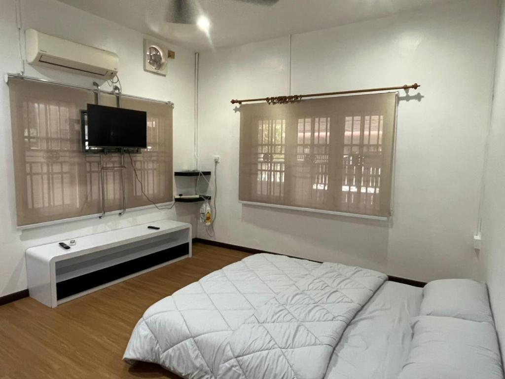 a bedroom with a bed and a flat screen tv at LIY Homestay in Gua Sai
