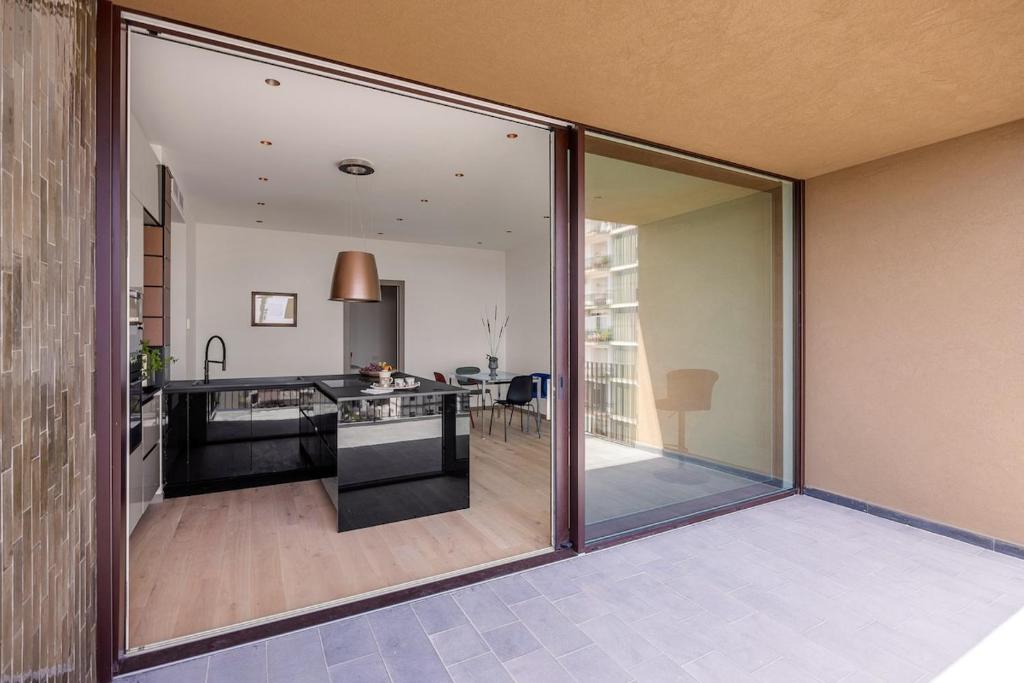 a kitchen with sliding glass doors leading into a living room at Top-Floor Sea View with Pool Access in Catania