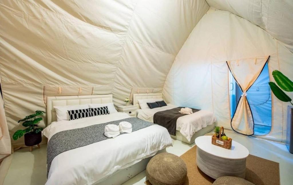 a bedroom with two beds in a tent at kingdom glamping in North Pattaya