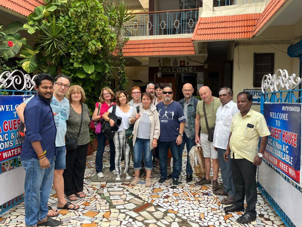 a group of people standing in front of a building at Siva Guest House in Mahabalipuram