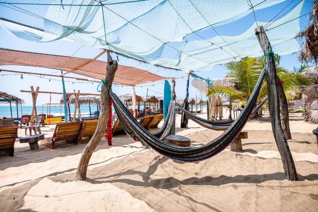 a hammock on a beach with chairs and the ocean at Drift Bay in Arugam Bay