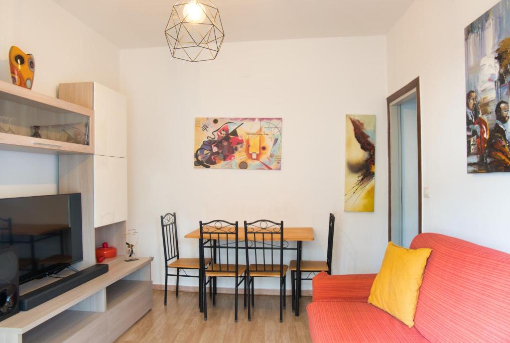 a living room with a red couch and a table at Tana del Manzoni in Barzio