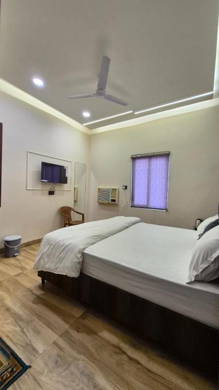 a bedroom with a large bed and a window at Hotel MRK VILLA in Varanasi