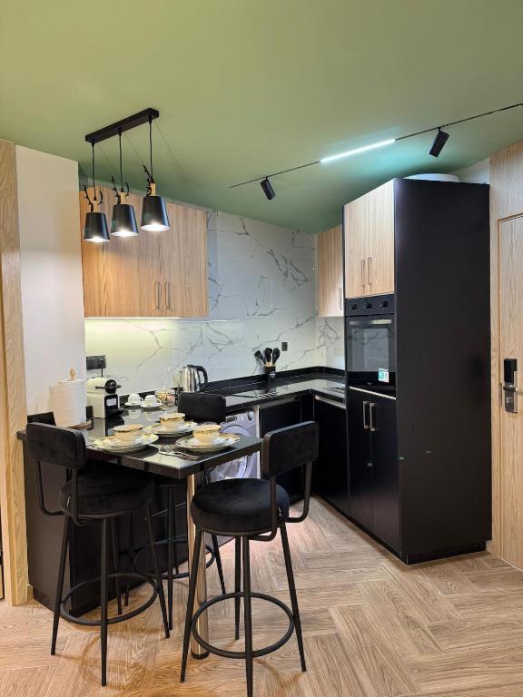 a kitchen with a table with chairs and a black refrigerator at Centrico 10 Confort & Luxe au Centre in Tangier