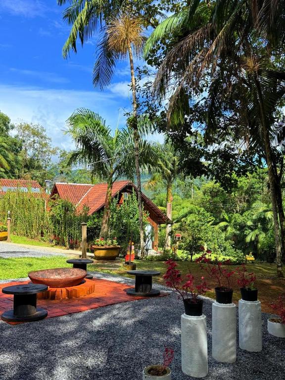 a park with benches and a table and trees at Pousada Passig in Guaramirim