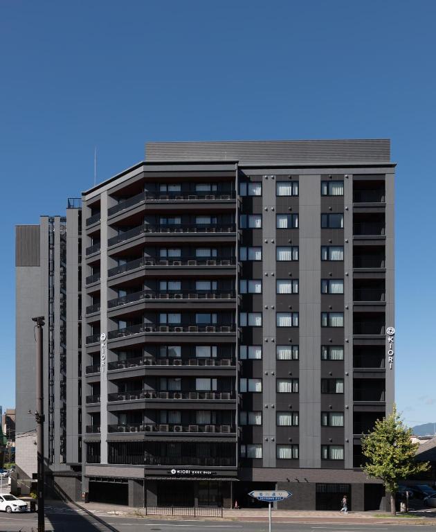 a tall apartment building on a city street at KIORI Exec Gojo in Kyoto