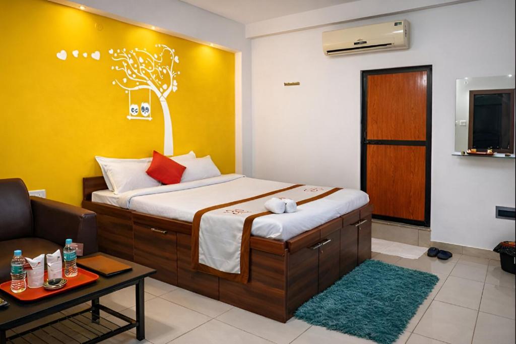 a bedroom with a bed and a couch and a tv at Hotel JK Lions - Koradi Road Nagpur in Nagpur