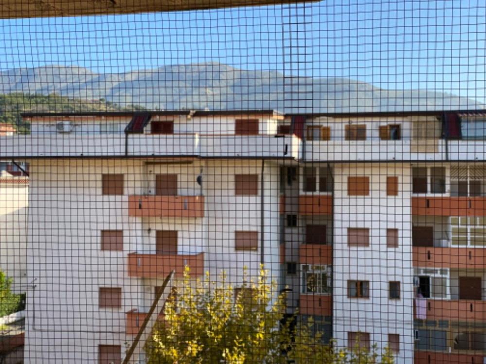 a view of a building behind a wire fence at Appartamento MiMoSa Scalea in Scalea
