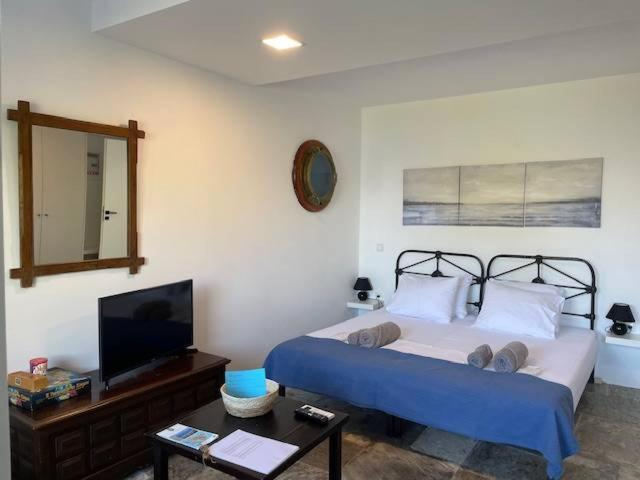 a bedroom with a bed and a mirror and a tv at Charming Spetses Studio with Outdoor Space in Spetses