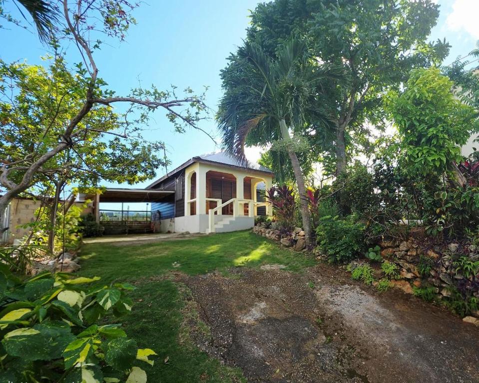 a house with a garden in front of it at Negril Humble Cabin in Negril