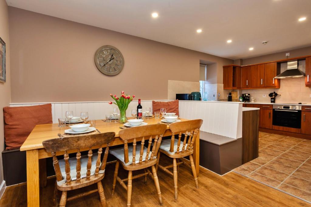 a kitchen and dining room with a wooden table and chairs at Finest Retreats - The Kiln in Bamburgh