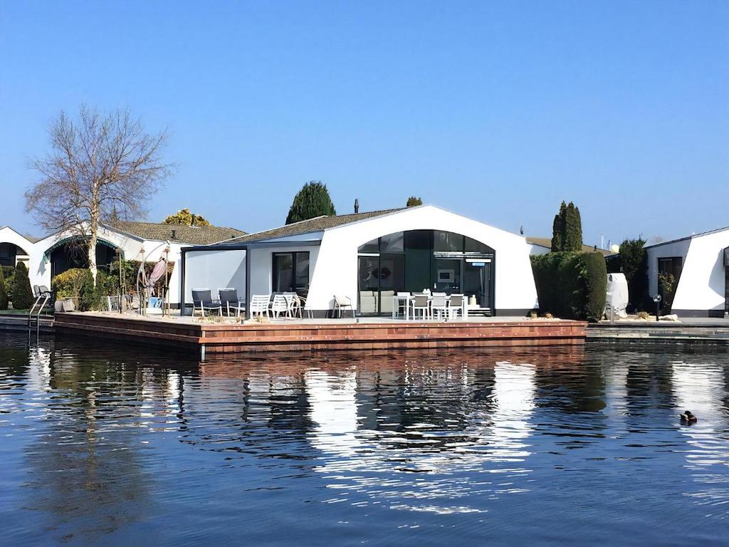 a house sitting on top of a body of water at Aquaronde 125 in Lemmer