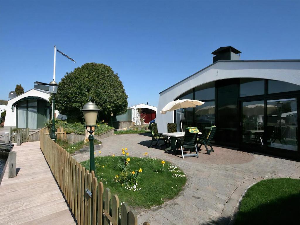 a house with a patio with a table and an umbrella at Aquaronde 129 in Lemmer