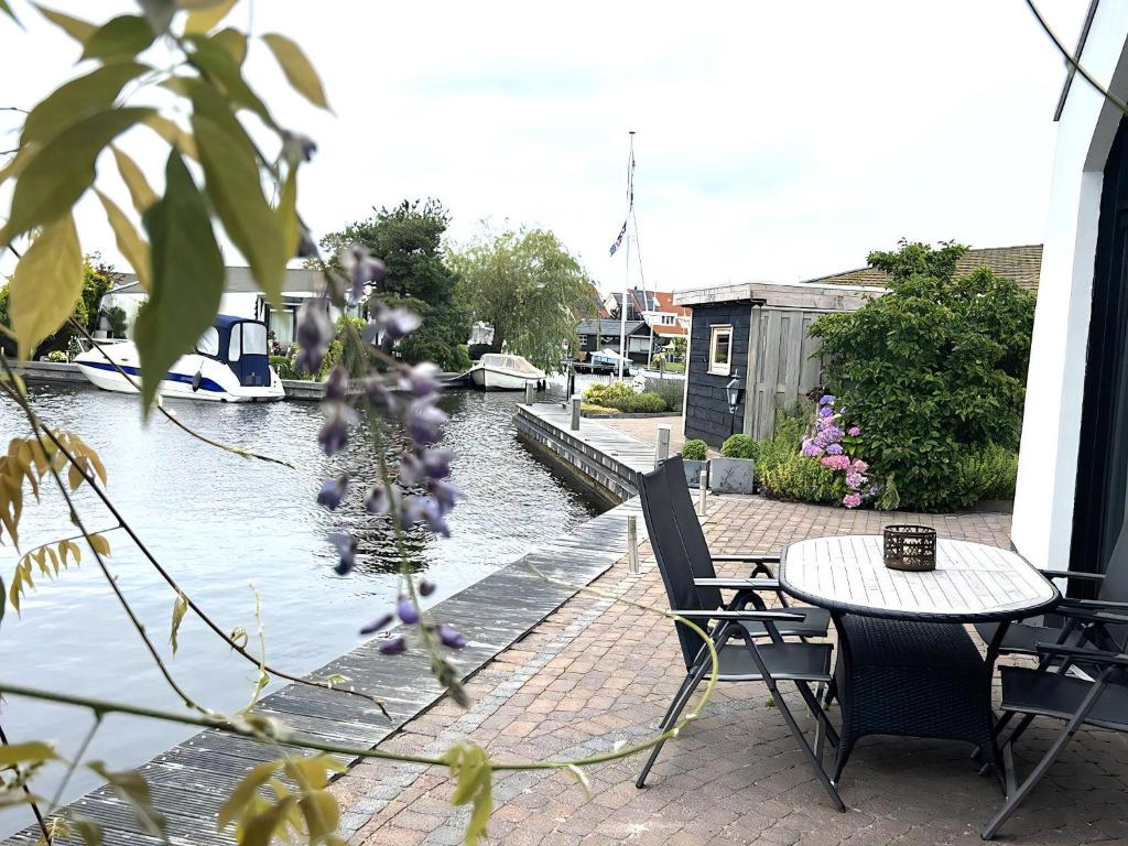a patio with a table and chairs next to a body of water at Aquaronde 120 in Lemmer