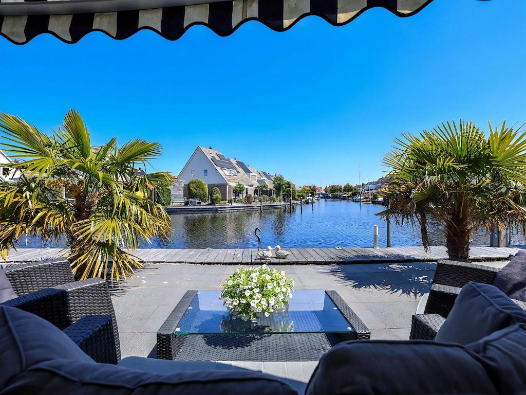 a view of a river with palm trees and a house at Aquaronde 050 in Lemmer