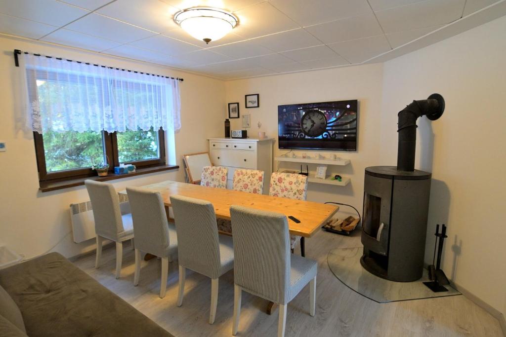 a dining room with a table and a wood stove at Andrea Chata in Štrba