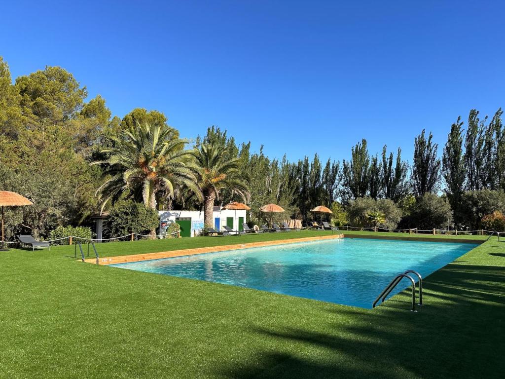 a swimming pool in the middle of a grass field at Camping Taiga Lake Caspe - Maeva Vacansoleil in Caspe