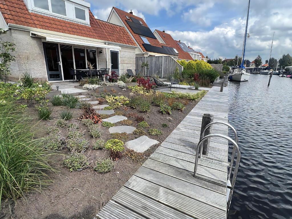 a bench sitting on a dock next to a house at Park De Marol Grutto 8 in Lemmer