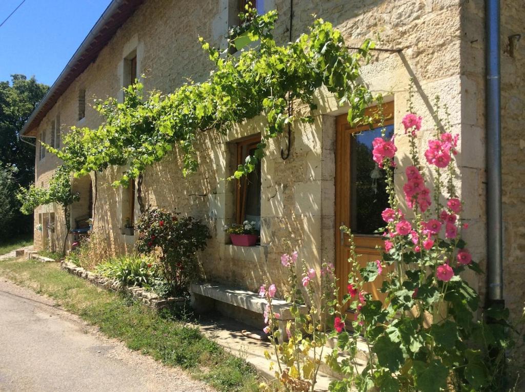 an old stone house with flowers in front of it at Le RepAire de La SalAmandre in Ivrey
