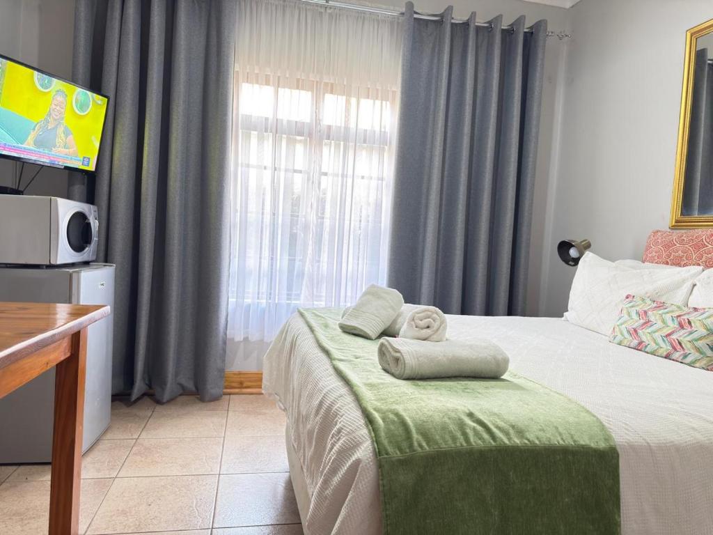 a bedroom with a bed with towels on it at Marico Bosveld Guesthouse in Zeerust