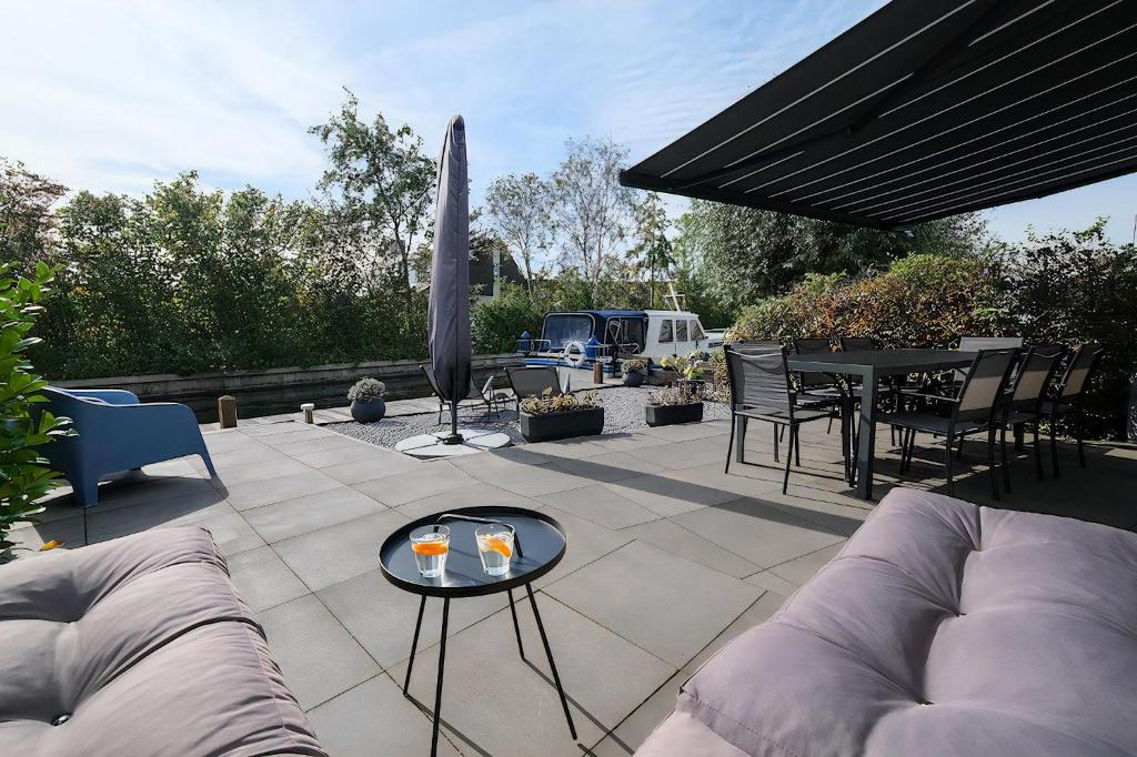 a patio with a couch and a table with drinks on it at Park Brekkense Wiel 103 in Lemmer
