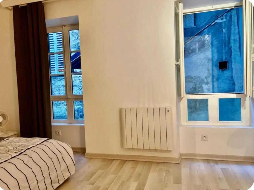 a bedroom with a bed and a large window at City centre appartement en colocation in Chambéry
